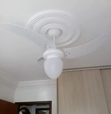 Tron Búzios instalado em quarto com teto branco, com detalhe de gesso redondo envolta do suporte