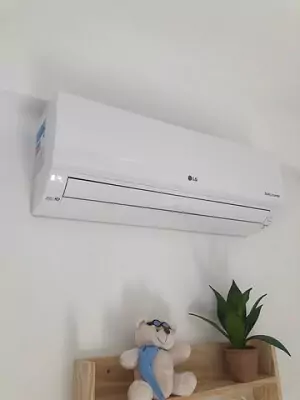 LG Dual Inverter Voice instalado em cima de estante de madeira com aletas fechadas