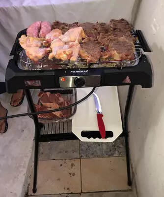 Mondial CH-06 apoiada em seu pedestal, ligada com pedaços de carne bovina e asa e coxa de frango