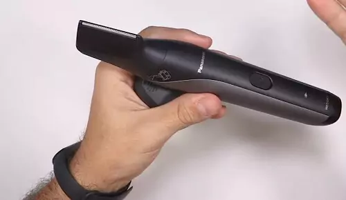 Mão masculina segurando o Panasonic V-Razor na horizontal.