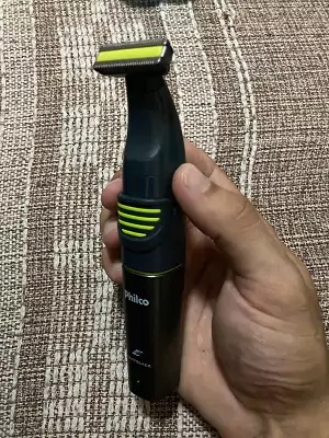 Mão masculina segurando o Philco Easyblade Plus na vertical dando destaque para sua lâmina.