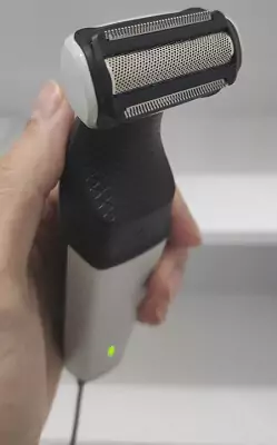 Mão masculina segurando o Philips BG3005 na vertical, dando destaque para sua lâmina dupla.