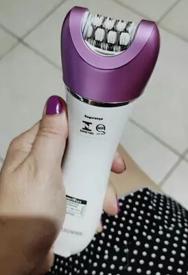 Visão de cima focalizada em mão feminina segurando o Britânia Aqua Sense, destacando seu bocal de pinças.