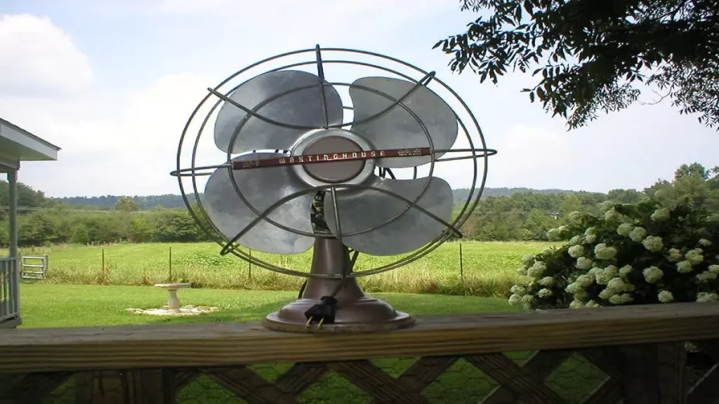 Abertura do post sobre quem inventou o ventilador: ventilador antigo em cima de cerca